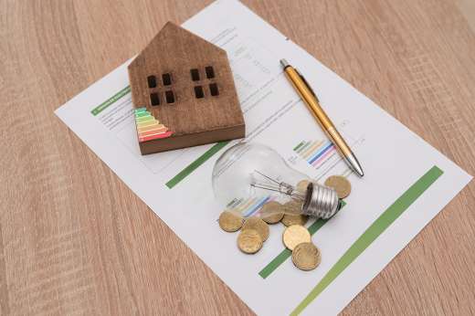 Foto: Glühbirne, Energieskala auf Haus, Münzen